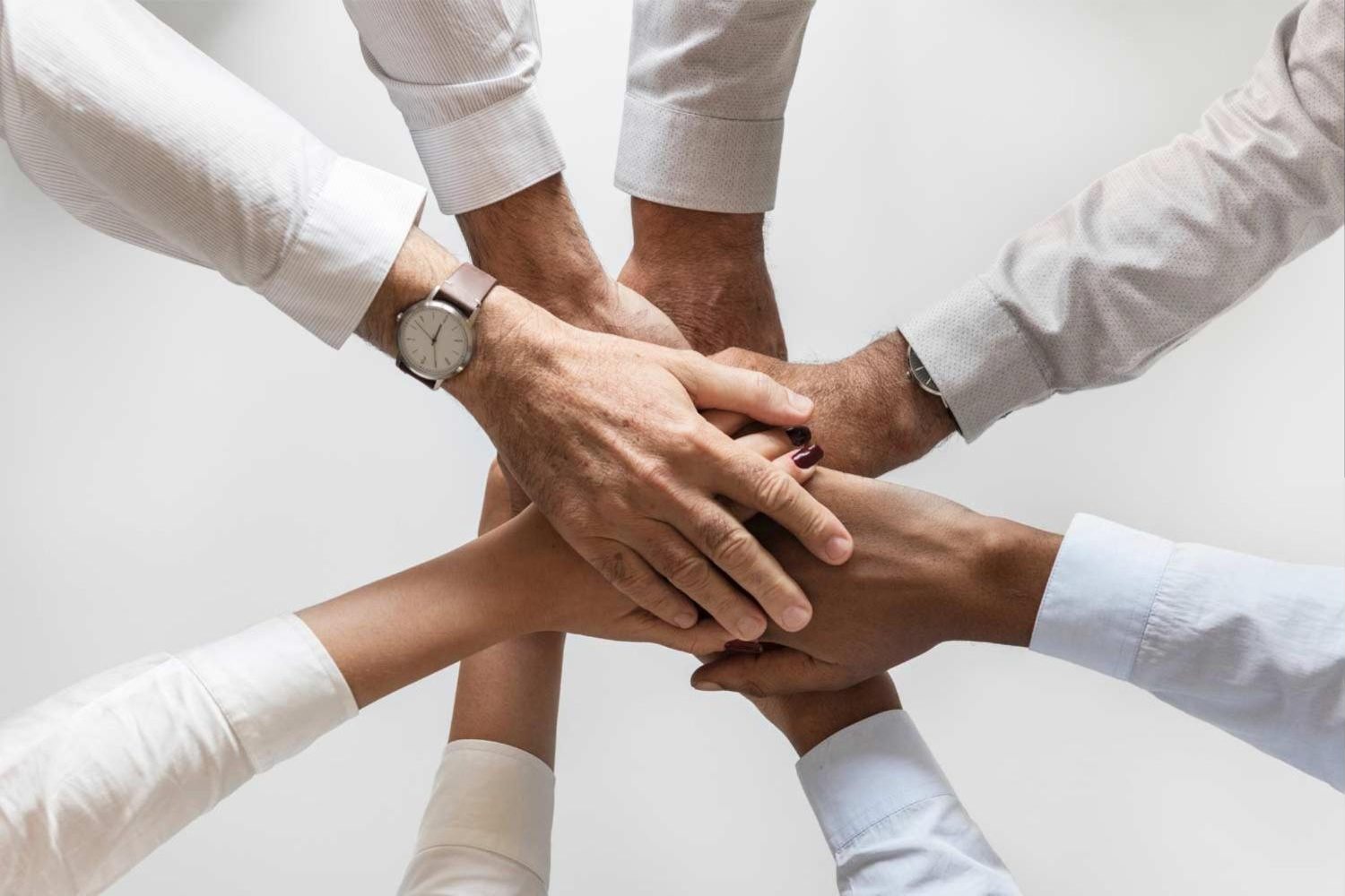 A team stacking their hands together